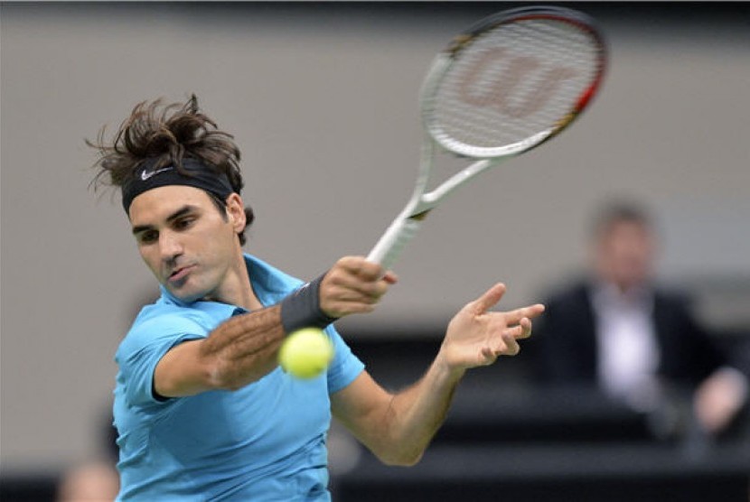 Petenis Swiss, Roger Federer, melepaskan pukulan saat menghadapi petenis tuan rumah, Thiemo De Bakker, di laga turnamen World Indoor di Ahoy Arena, Rotterdam, Belanda, Kamis (14/2). 