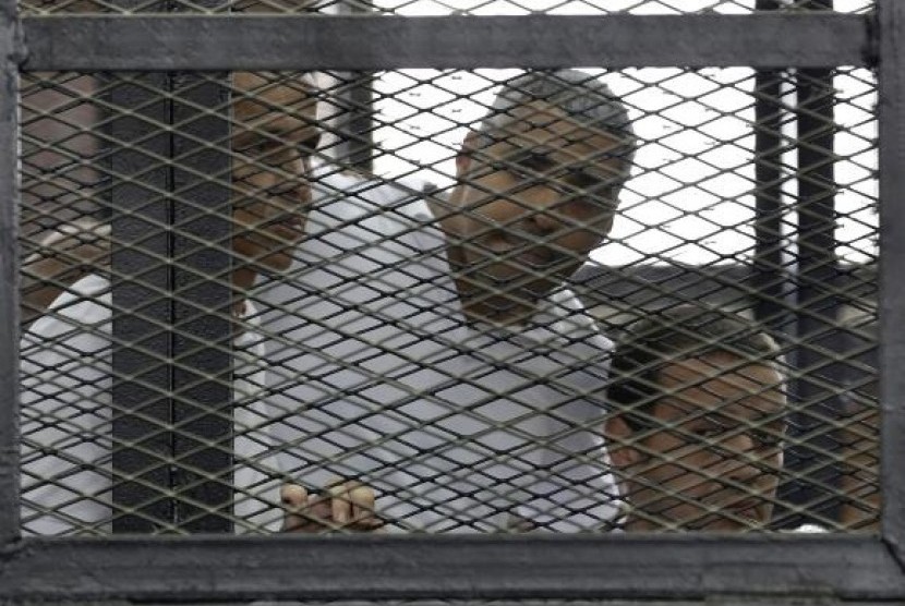 Peter Greste, Mohamed Fahmy and Baher Mohamed (left to right) listen to the ruling at a court in Cairo June 23, 2014.