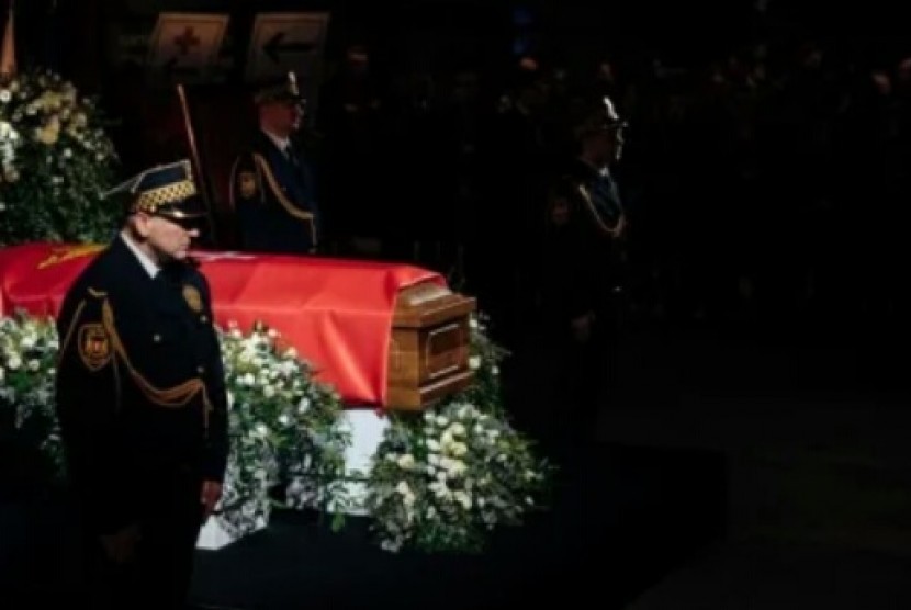 peti mati Adamowicz terbungkus jubah merah.