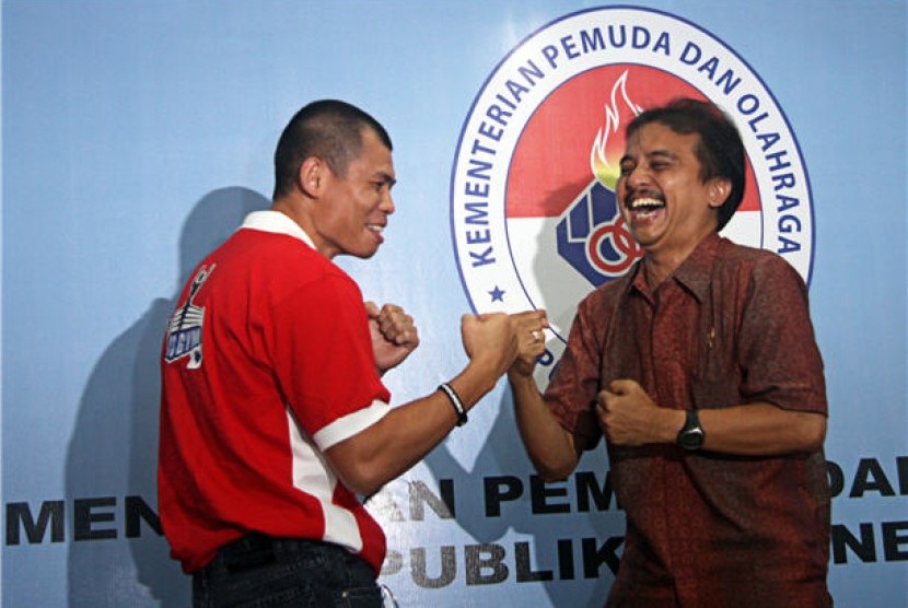 Petinju Indonesia Chris John (kiri) bercanda dengan Menteri Pemuda dan Olahraga Roy Suryo (kanan) pada kunjungannya ke kantor Kemenpora, Senayan, Jakarta, Jumat (1/3). 