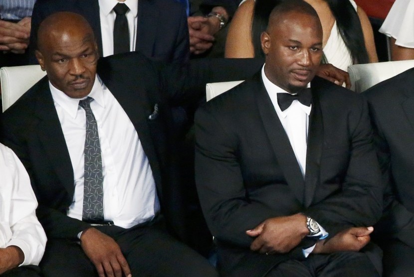 Mantan petinju Mike Tyson dan Lennox Lewis (kanan) duduk berdampingan di pemakaman Muhammad Ali.