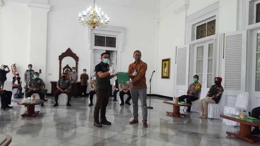 Petrus Adamsantosa, Pemilik Javaretro Suites Hotel menyerahkan bantuan APD ke Gubernur Jabar Ridwan Kamil. 
