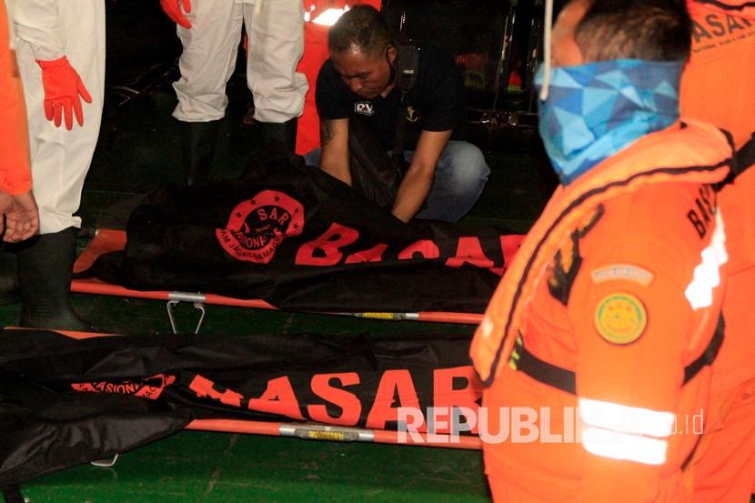 Petuga kepolisian memeriksa kantong jenazah korban kapal tenggelam di Pelabuhan Tenau Kupang, NTT, Ahad (5/7). Kepolisian Resor Rote Ndao melaporkan seorang bayi berusia 11 bulan dilaporkan meninggal dunia di Puskesmas di daerah itu setelah menjalani perawatan intensif. 