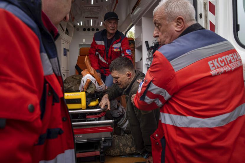 Petugas ambulans membantu seorang prajurit Ukraina yang terluka untuk pindah ke rumah sakit di wilayah Donetsk, Ukraina timur, Sabtu, 23 April 2022. Invasi Rusia ke Ukraina telah menghancurkan ratusan rumah sakit dan fasilitas medis lainnya.