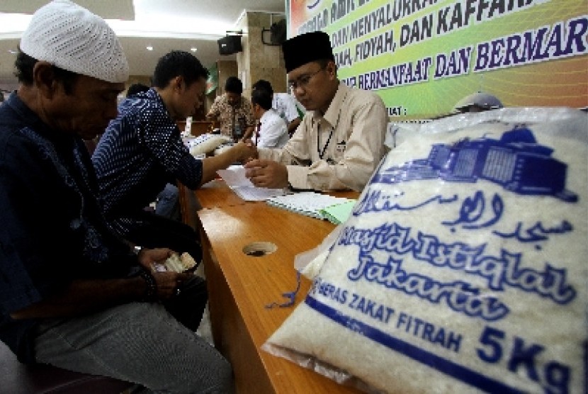 Petugas amil zakat membimbing warga yang akan membayar zakat fitrah di Masjid Istiqlal, Jakarta.