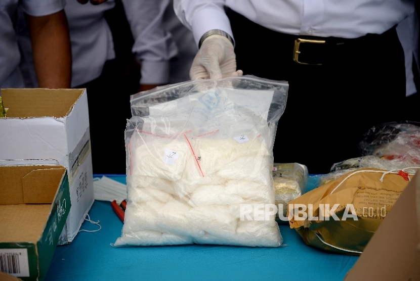 Petugas Badan Narkotika Nasional (BNN) menunjukan barang bukti narkotika jenis sabu dan pil ekstasi sebelum dilakukan pemusnahan di Kantor BNN, Jakarta,Kamis (16/3). 
