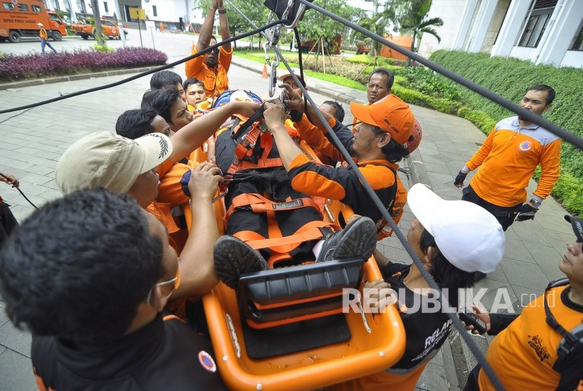 Petugas Badan Nasional Penanggulangan Bencana (BNPB) melakukan evakuasi korban bencana saat glasi bersih simulasi penanganan bencana gempa di Halaman Gedung Sate, Jalan Diponegoro, Kota Bandung, Senin (24/4).