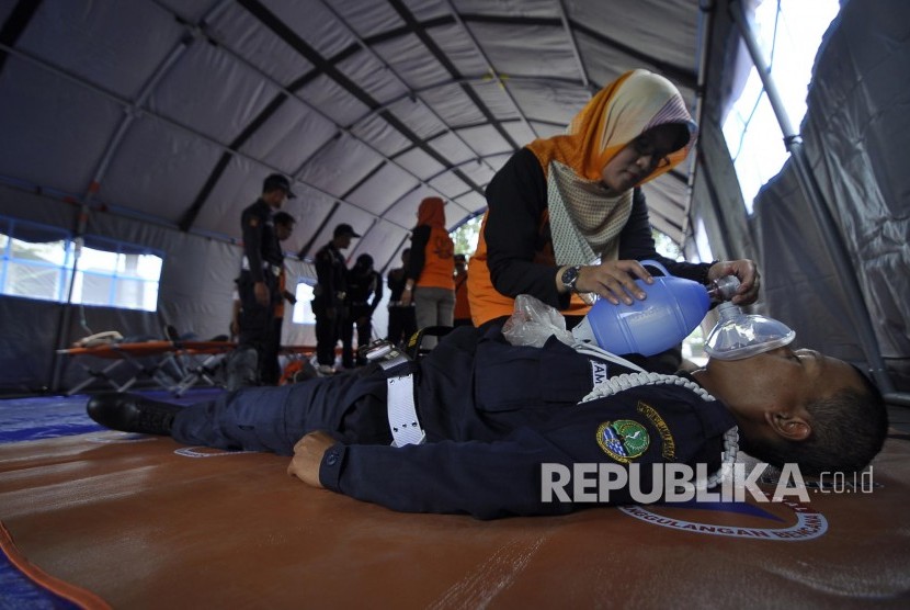 Petugas Badan Nasional Penanggulangan Bencana (BNPB) melakukan evakuasi korban bencana saat glasi bersih simulasi penanganan bencana gempa di Halaman Gedung Sate, Jalan Diponegoro, Kota Bandung, Senin (24/4).