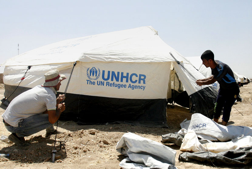  Petugas Badan PBB Urusan Pengungsi (UNHCR) mendirikan tenda pengungsian untuk warga Irak yang mengungsi di kota Erbil, Irak. 