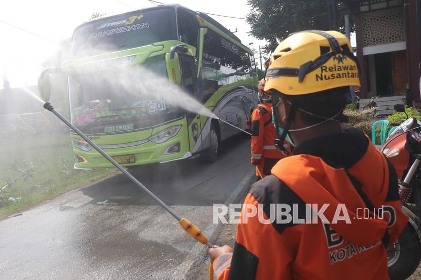 Petugas Badan Penanggulangan Bencana Daerah (BPBD) menyemprotkan disinfektan pada bus yang digunakan untuk memulangkan santri Lirboyo ke daerah asal di Kediri, Jawa Timur, Kamis (8/4/2021). Ponpes Lirboyo memasuki libur panjang tahun ajaran baru memulangkan sebanyak 15 ribu santri menggunakan kendaraan yang telah disiapkan dan melarang penggunaan kendaraan umum guna menghindari penularan COVID-19.