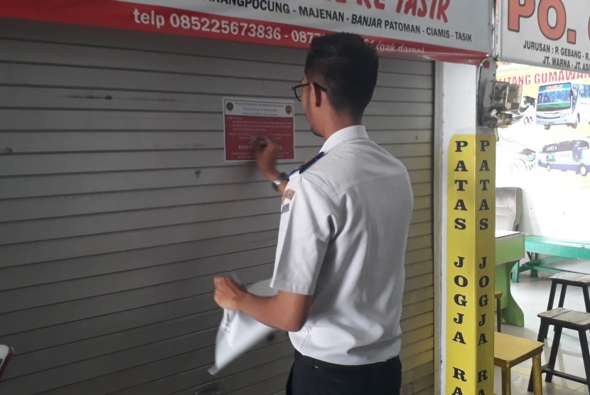 Petugas Balai Pengelola Transportasi Darat (BPTD) Wilayah X Jawa Tengah dan DIY, memasang sticker penutupan (penyegelan) pada salah satu kios yang ada di dalam lingkungan Terminal Bus Tipe A Bawen, Kabupaten Semarang, Selasa (6/8). 