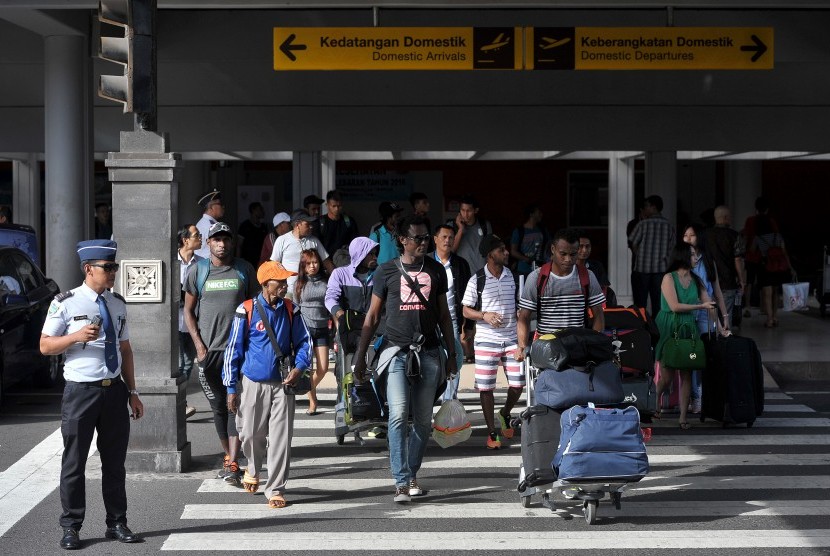 Petugas bandara mengawasi penumpang yang baru tiba di terminal kedatangan domestik Bandara Ngurah Rai, Denpasar, Jumat (24/6).