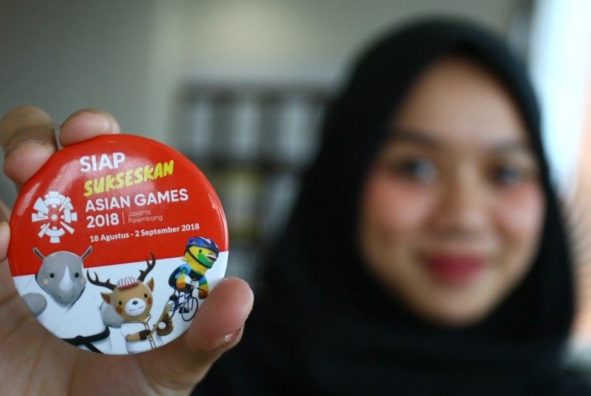 Petugas bandara menunjukkan pin dukungan terhadap pelaksanaan pesta olahraga Asian Games 2018 seusai Deklarasi Komitmen Dukungan Penyelenggaraan Asian Games 2018 Komunitas Bandara Soekarno Hatta (KOMBATTA) di kawasan bandara Soekarno Hatta, Tangerang, Banten, Kamis (12/7). 