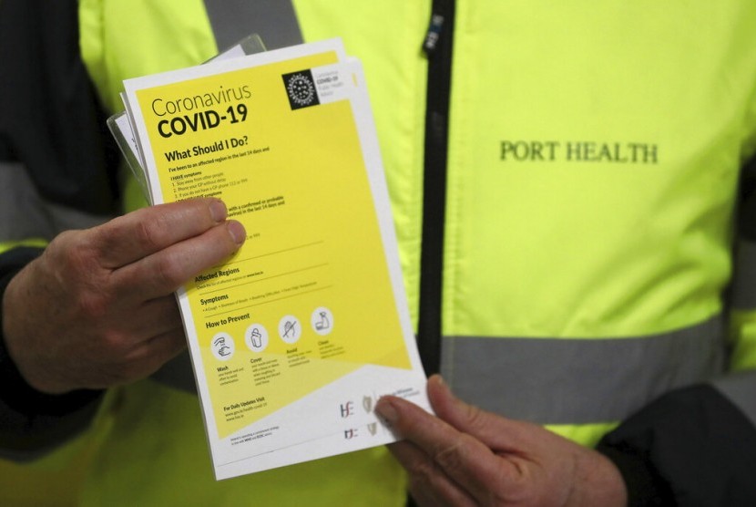 Petugas bandara menunjukkan selebaran sebagai bagian dari kesadaran masyarakat terkait penyebaran virus corona, di ruang Bagasi Terminal 2 Bandara Dublin, Irlandia, Jumat (28/2). Otoritas Irlandia mengumumkan kasus pertama corona di negaranya.