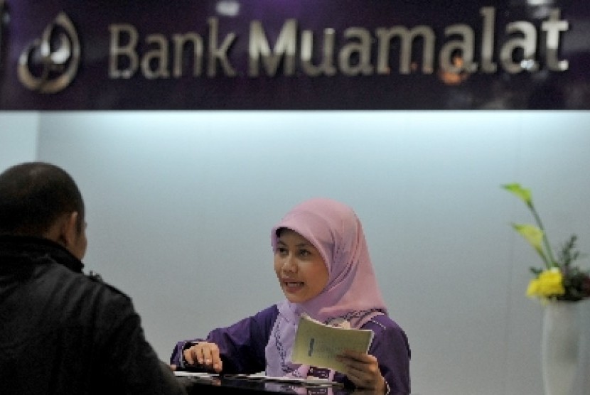 Petugas bank melayani nasabah di Bank Muamalat, Jakarta.