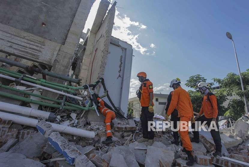 Petugas Basarnas melakukan pencarian korban gempa dan tsunami di Hotel Roa Roa, Palu, Sulawesi Tengah, Ahad (30/9). 