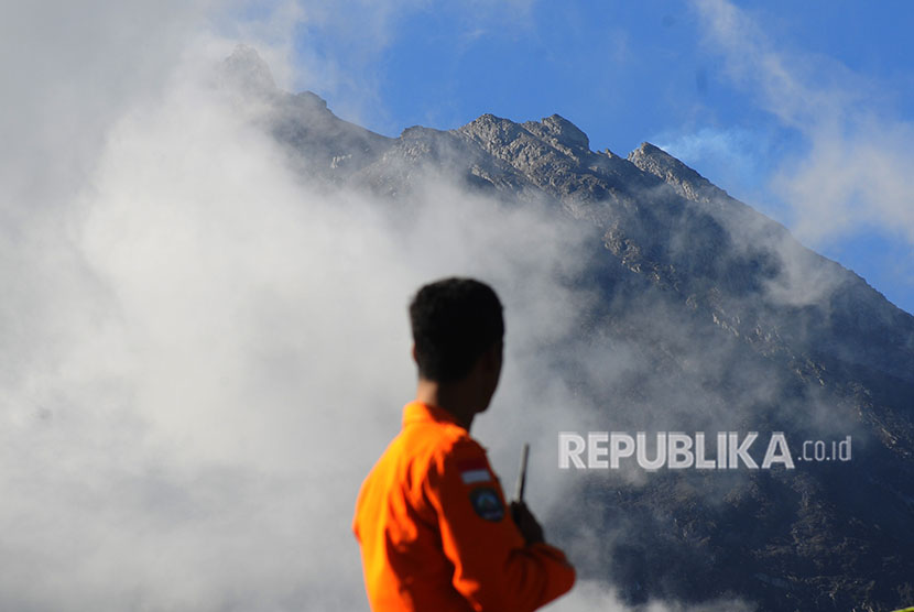 Petugas Basarnas mengamati puncak Gunung Merapi dari Stabelan, Tlogolele, Selo, Boyolali, Jawa Tengah, Selasa (22/5). 