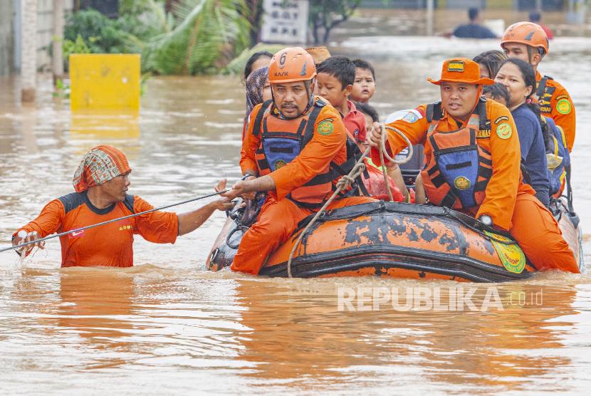 Petugas Basarnas mengevakuasi warga terdampak banjir di Desa Purwasari, Karawang, Jawa Barat, Selasa (25/2). Banjir mengakibatkan sejumlah gardu listrik di Karawang dipadamkan untuk keselamatan warga.
