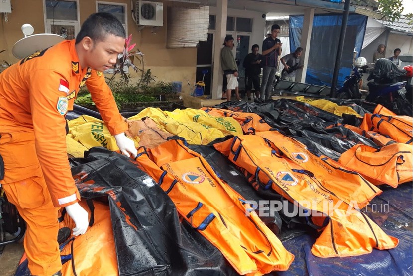 Petugas Basarnas mengumpulkan jenazah korban tsunami di pesisir Cinangka, Serang, Banten, Ahad (23/12).