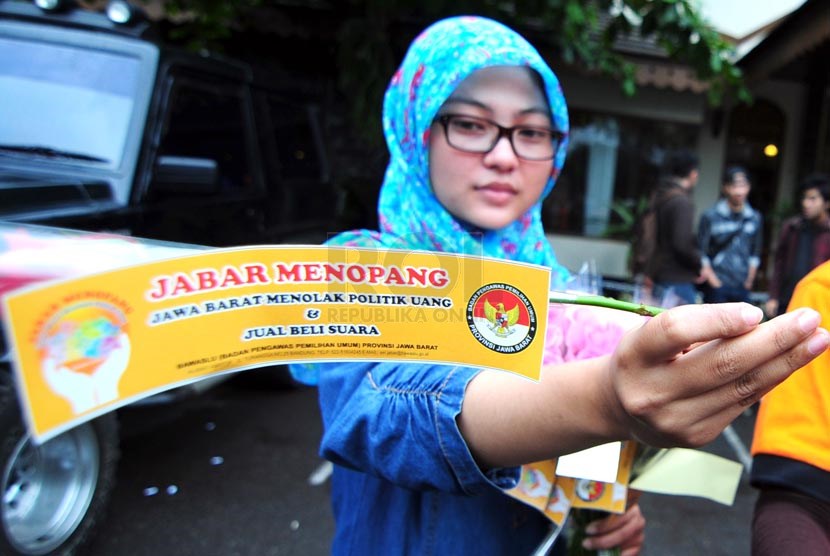 Petugas Bawaslu Jabar memperlihatkan bunga dan stiker sebagai bentuk sosialisasi pemilu bersih di Jalan Surapati, Bandung. (Ilustrasi)