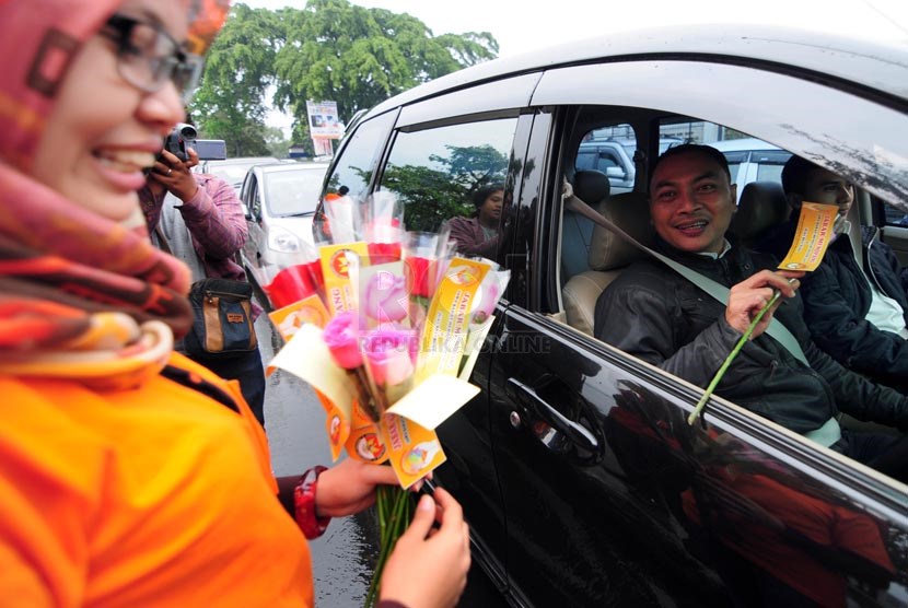   Petugas Bawaslu Jabar memperlihatkan bunga dan stiker sebagai bentuk sosialisasi pemilu bersih di Jalan Surapati, Bandung, Kamis(27/3).  (foto: Septianjar Muharam)