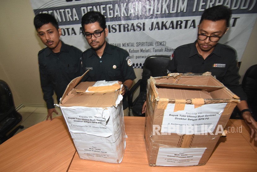Petugas Bawaslu Jakarta Pusat menunjukkan kardus berisi ribuan form C1 Pemilu yang diamankan polisi dari sebuah mobil yang melaju di kawasan Menteng, Jakarta, di Gedung Bawaslu Jakarta Pusat, Senin (6/5/2019).