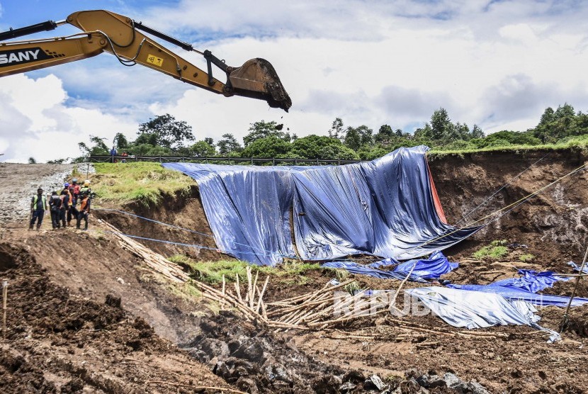 Petugas berada di area pemasangan perkuatan lereng di lokasi pergerakan tanah yang menyebabkan longsor di KM 118 Tol Cipularang, Kabupaten Bandung Barat, Senin (17/2).