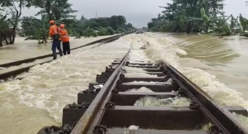 Petugas berada di atas rel yang terendam banjir di KM 55+100 - KM 54+500, tepatnya antara Kedunggedeh - Lemah Abang, Kabupaten Bekasi, Ahad (21/2). Akibatnya, semua perjalanan KA jarak jauh dari Stasiun Pasar Senen dibatalkan.