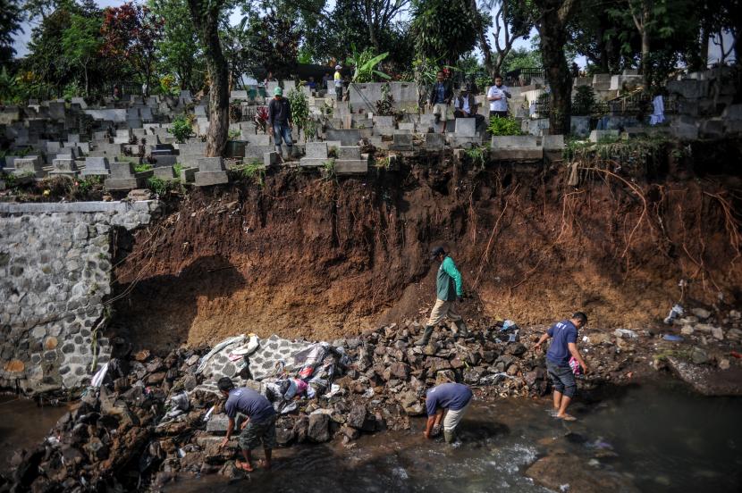 Petugas berada di lokasi longsornya pemakaman di TPU Sirnaraga, Bandung, Jawa Barat, Rabu (5/10/2022). Hujan deras pada Selasa (5/10/2022) membuat sebagian pemakaman di TPU Sirnaraga longsor dan membuat sejumlah warga memindahkan jenazah yang masih utuh ke tempat yang lebih layak. 