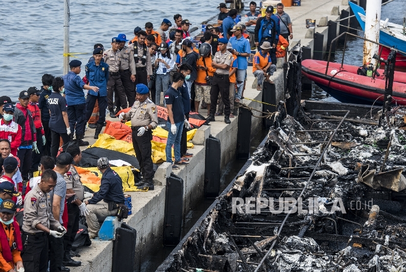 Petugas berada di sekitar kantong jenazah korban kebakaran kapal motor Zahro Express di Pelabuhan Kali Adem, Muara Angke, Jakarta, Ahad (1/1).ANTARA FOTO/M Agung Rajasa