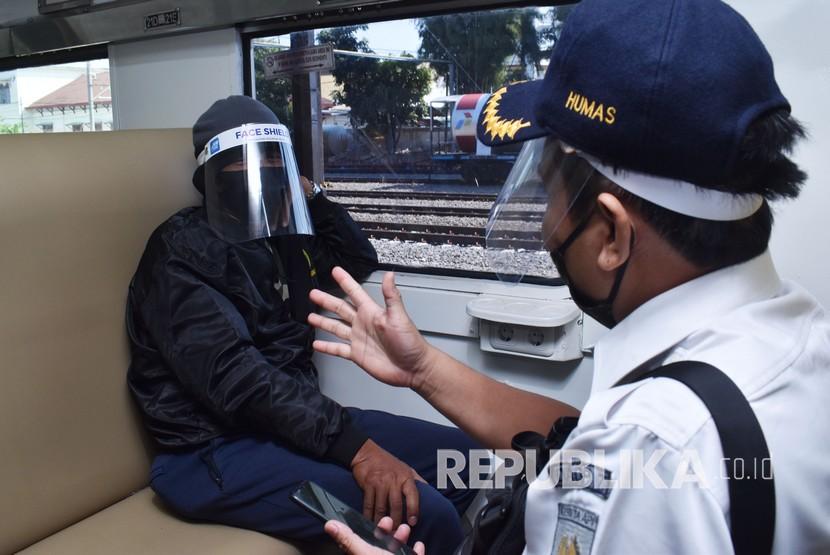 [Ilustrasi] Petugas berbincang dengan penumpang yang mengenakan masker dan pelindung wajah di Kereta Api (KA) Sri Tanjung relasi Lempuyangan Yogyakarta-Ketapang Banyuwangi.