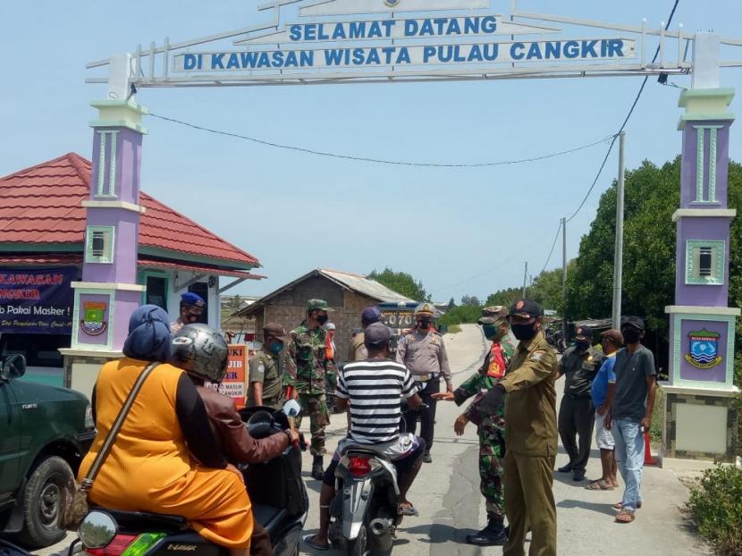 Petugas berjaga di gerbang menuju Pantai Tanjung Kait di Desa/Kecamatan Kronjo, Kabupaten Tangerang, Banten.