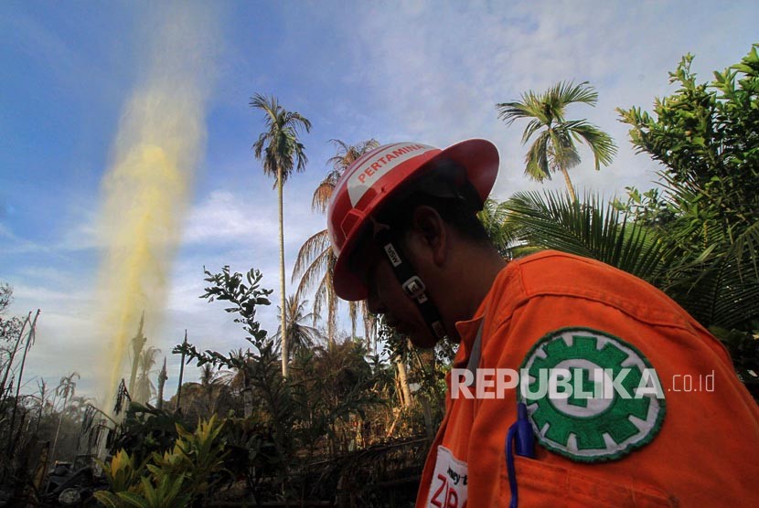 Petugas berjaga di lokasi ledakan sumur minyak ilegal yang telah padam di Desa Pasir Putih, Rantau Pereulak, Aceh Timur, Aceh, Kamis (26/4). 