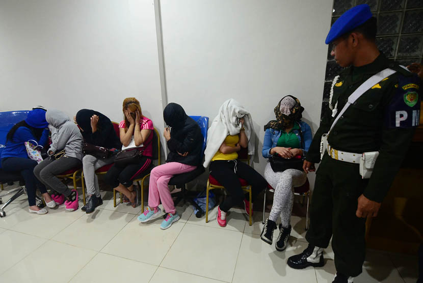 Petugas berjaga disamping Pekerja Seks Komersial (PSK) asal Maroko di Kantor Imigrasi wilayah Bogor, Jabar, Rabu (4/12) malam.