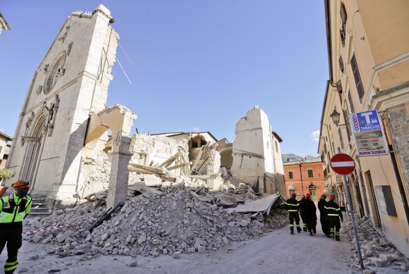 Petugas berjalan di reruntuhan katedral di Norcia, Italia, (31/10). Italia kembali diguncang gempa kuat.