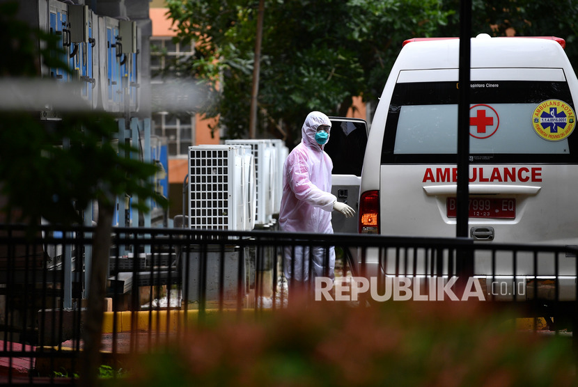 Petugas berjalan ke arah mobil ambulans yang terparkir di samping ruang isolasi RSPI Prof. Dr. Sulianti Saroso, Sunter, Jakarta Utara, Kamis (5/3/2020).