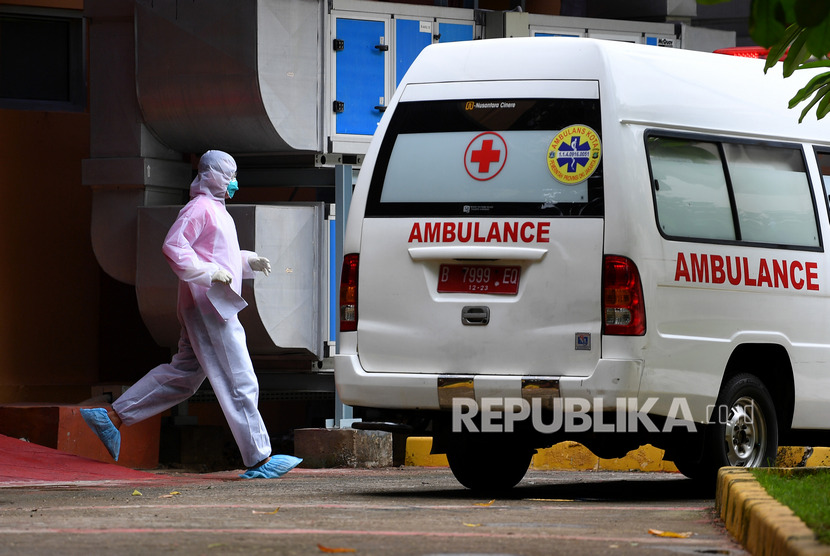 Petugas berjalan ke arah mobil ambulans yang terparkir di samping ruang isolasi RSPI Prof. Dr. Sulianti Saroso, Sunter, Jakarta Utara, Kamis (5/3/2020).(Antara/Sigid Kurniawan)