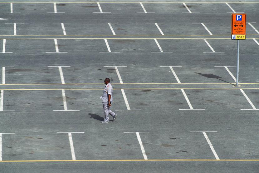 UEA Lakukan Tes Corona Terhadap 125 Ribu Orang . Petugas berjalan melalui tempat parkir yang biasanya penuh di Dubai, Uni Emirat Arab, Senin (16/3). Warga Dubai memilih berada di rumah akibat pandemi virus corona. (AP Photo/Jon Gambrell)