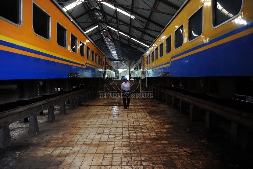 Petugas berjalan saat mengecek kesiapan perbaikan gerbong kereta api di Balai Yasa, Manggarai, Jakarta, Rabu (1/7).