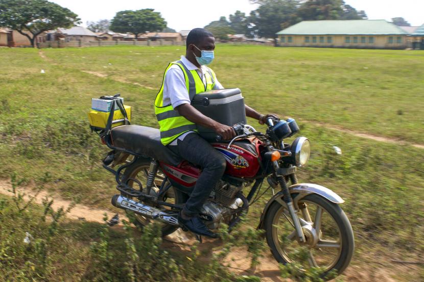 Petugas berkendara membawa boks berisi vaksin AstraZeneca di Sabon Kuje, di pinggiran Abuja, Nigeria, Senin (6/12). Sebanyak satu juta vaksin Covid-19 di Nigeria diperkirakan telah kedaluwarsa di Nigeria bulan lalu.