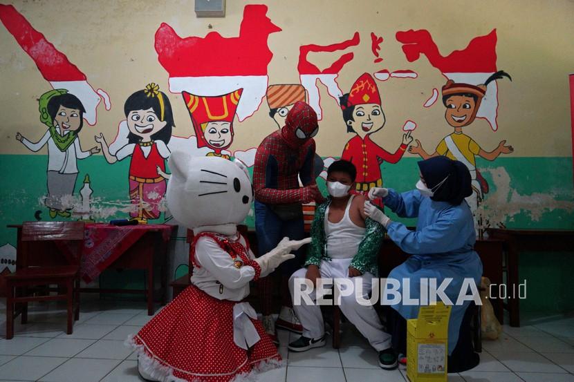 Petugas berkostum super hero Spiderman dan tokoh Hello Kitty mendampingi seorang anak saat vaksinasi COVID-19 dosis ke-2 untuk anak usia 6-11 tahun di SD N 1 Keceme, Caturharjo, Sleman, D.I Yogyakarta, Sabtu (19/2/2022). Vaksinasi bersama super hero tersebut guna meningkatkan minat anak-anak mengikuti vaksinasi COVID-19 dosis ke-2.