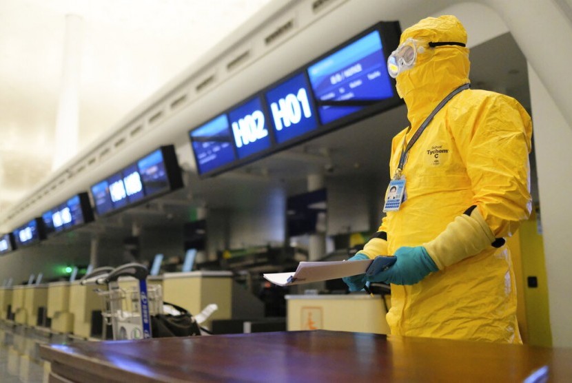 Petugas berpakaian pelindung lengkap berdiri di ruang check in di Wuhan Tianhe International Airport, Kota Wuhan, Provinsi Hubei, China. Maskapai penerbangan China melaporkan kerugian 4,8 miliar dolar AS akibat pandemi corona. Ilustrasi.