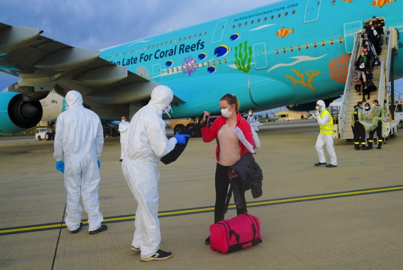Petugas berpakaian pelindung lengkap mengecek barang penumpang yang berhasil dievakuasi dari Wuhan, China, di bandara Marseilles, Prancis, Ahad (2/2). 