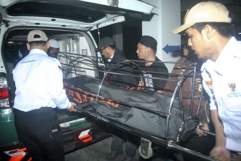 Petugas bersama anggota keluarga memindahkan jenazah korban kecelakaan di Cikidang, Sukabumi