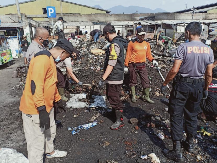Petugas bersama masyarakat bergotong royong membersihkan puing-puing sisa kebakaran yang terjadi di Pasar Ciawi, Kabupaten Tasikmalaya, Jumat (20/8).