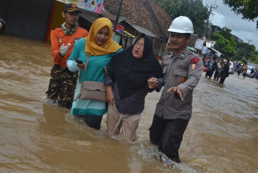 Petugas bersama relawan membantu mengevakuasi korban banjir di Pasar Labuan, Labuan, Pandeglang, Banten, Selasa (1/1/2019).