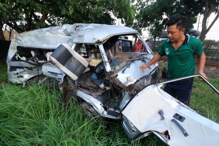 Petugas bersiap memindahkan mobil Mitsubisi L300 bernopol P 1264 DE yang ringsek akibat kecelakaan dengan kereta api di lintasan rel di Dusun Rohkepuh, Beji, Pasuruan, Jawa Timur, Rabu (9/1/2019).