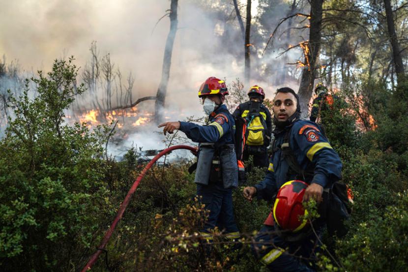 Petugas berupaya memadamkan kebakaran hutan di Pulau Kos, Yunani. 