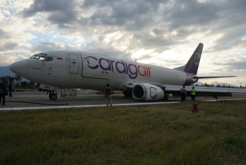 Petugas berusaha melakukan pengamanan dan evakuasi pesawat kargo milik maskapai Cardig Air yang tergelincir di Bandara Wamena, Puncak Jaya, Papua, Jumat (28/8). 