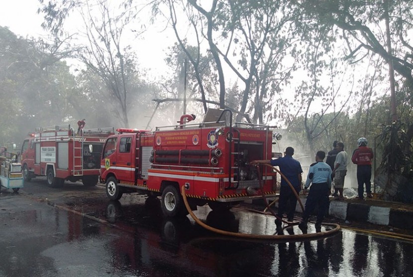 Petugas berusaha memadamkan api di lokasi kebakaran barang bekas di Ciluar, Bogor,Selasa (27/10).